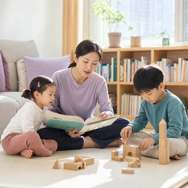 한국인 아이돌봄사가 가정에서 두 아이에게 책 읽기와 블록 놀이 돌봄을 제공하는 모습